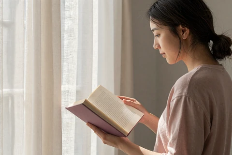 Woman reading thoughtfully in natural light illustrating research on what women prioritize in partners